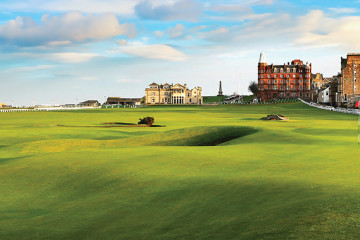 The fairway of the 18th hole under cloud-streaked sky at the Old Course at St Andrews alongside the town of St Andrews, Scotland.