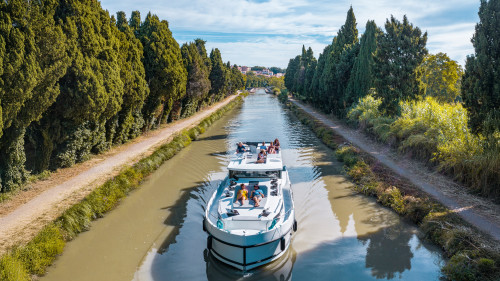A canal boat cruises the scenic Canal du Midi along the Canal du Midi, offering a relaxing way to explore southern France.