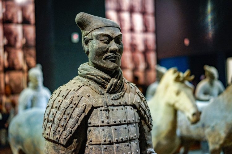 Tonkrieger im Vordergrund mit Pferdestatuen im Hintergrund im Qin Shi Huang Mausoleum Museum​​ in Xian China