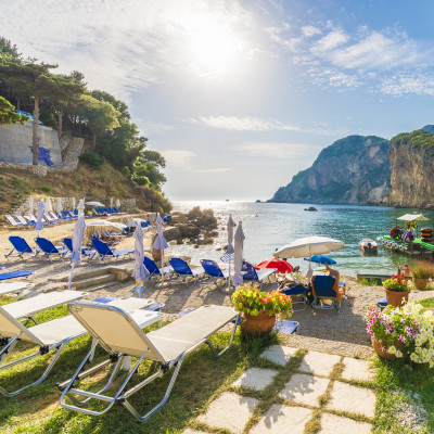Sunbeds and umbrella on the beach in Corfu Island, Greece.