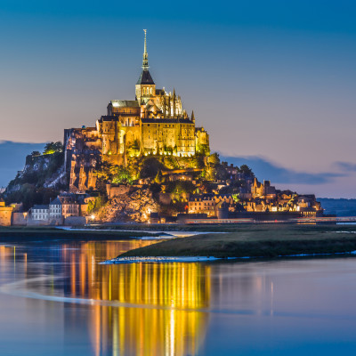 Beautiful view of famous Le Mont Saint-Michel tidal island in beautiful twilight during blue hour at dusk, Normandy, northern France