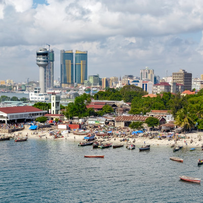 Fisherman boats in front of Kivukoni fish market with Port control tower and Skyscrapers Behind, Dar Es Salaam, Tanzania