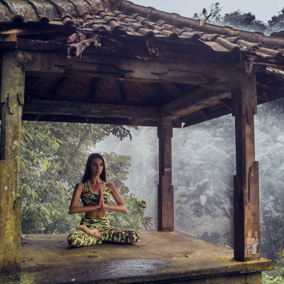 Woman practices yoga at Sekumpul waterfall on Bali in Indonesia, Asia
