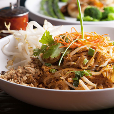Chicken pad Thai with a variety of other fine Thai food dishes. Shallow depth of field