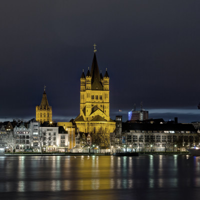 Illuminated buildings and cologne cathedral by rhine river in city at night, Germany, Europe