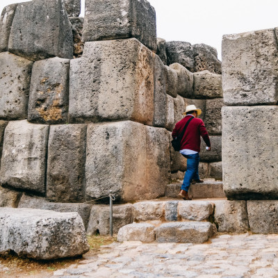 Man entering in front of the huge rocks of Sacsayhuaman in Cusco - Peru, South America
