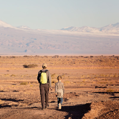 back view of father and son hiking together in atacama desert, chile, South America
