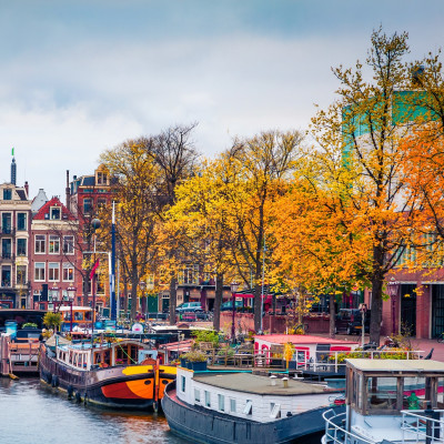 Panoramic autumn view of Amsterdam city. Famous Dutch channels and great cityscape. Gloomy morning scene of Netherlands, Europe. Traveling concept background. European Cities tours