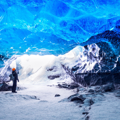 Traveler in ice cave, man standing underground inside of a glacier, climate specific, Vatnajokull National Park, amazing nature of Skaftafell, Iceland