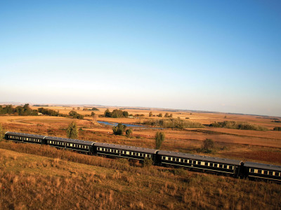 a large long train on a track near a field