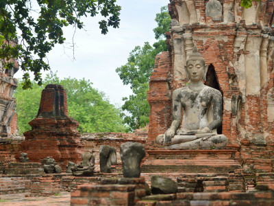 a large stone statue in front of a brick building