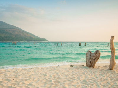 a sandy beach next to a body of water