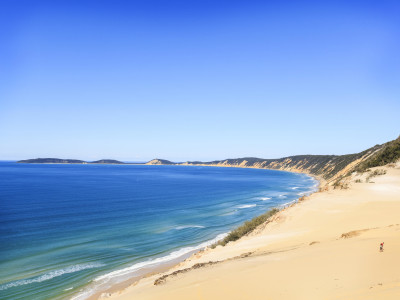 a sandy beach next to a body of water