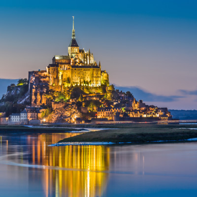 Beautiful view of famous Le Mont Saint-Michel tidal island in beautiful twilight during blue hour at dusk, Normandy, northern France