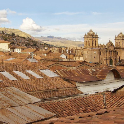 Twin towers and dome of the historic Iglesia de la Compania seen across the red rooftops of Cusco in Peru, South America