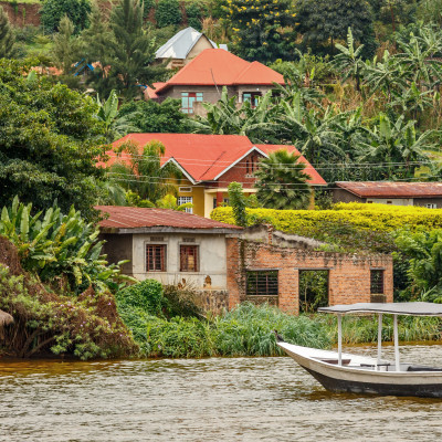 Roof boat anchored at the coast with rwandan village in the background, Kivu lake, Rwanda