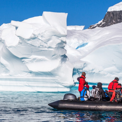 Enchanting Travels Antarctica Tours Boat full of tourists explore huge icebergs