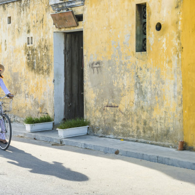 Vietnam girls with a vietnamese traditional costume wearing Ao dai ride a bicycle at Hua, Asia