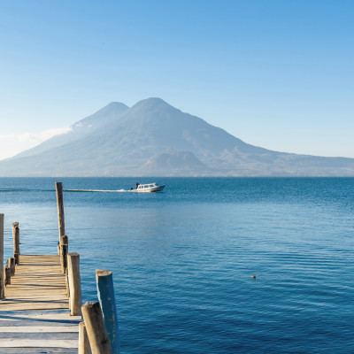 Wooden jetty on Lake Atitlan on the shore in Panajachel, Guatemala. With beautiful landscape of volcanoes landscape