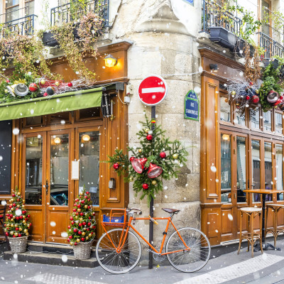 Enchanting Travels France Tours Bicycle is parked at typical Parisian cafe decorated for Christmas