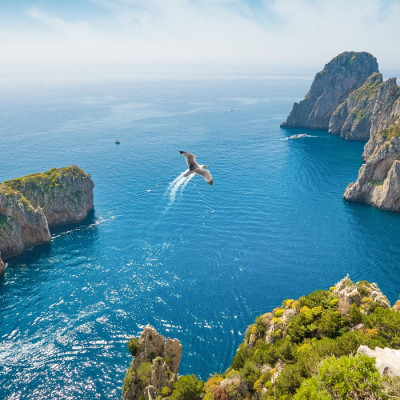 Enchanting Travels Italy Tours Aerial view of famous Faraglioni rocks from Capri island, Italy.