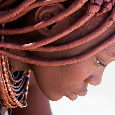 Enchanting Travels Namibia Tours Profile of a Himba woman looking down.
