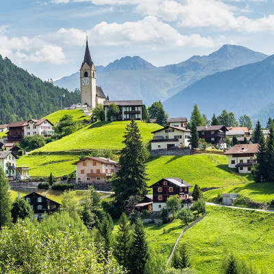 Graubuenden, Switzerland with view of houses on green grassy hills