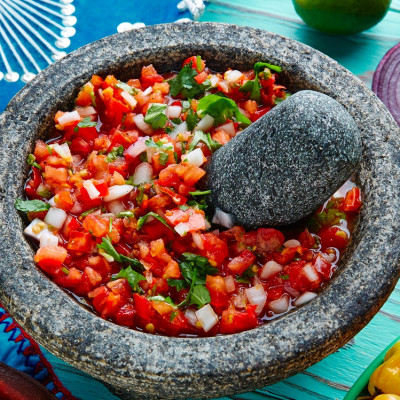 Mexican cuisine Pico de Gallo sauce from Mexico with tomato cilantro and onion in molcajete