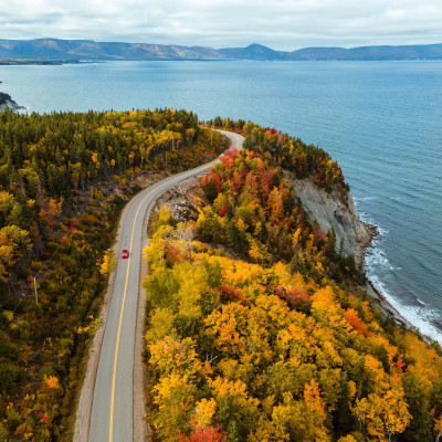 Luftaufnahme mit Fokus auf den herbstlich gefärbten Wald entlang der Panoramastrasse Cabot Trail auf Cape Breton in Nova Scotia Kanada