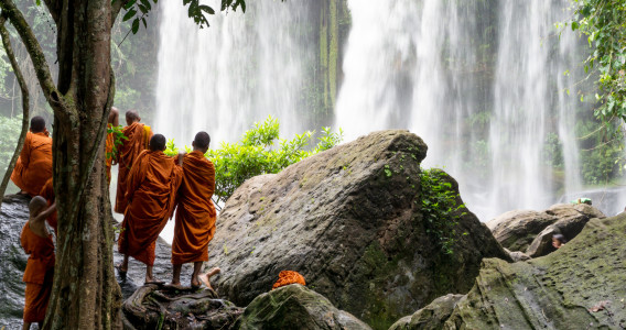 Group of young buddhist monks enjoying the view of Kulen Waterfall in Cambodia, Asia