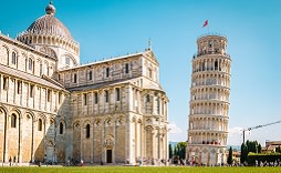 Enchanting Travels Italy Tours Leaning tower of Pisa, Italy with Basilica and Cathedral on a bright summer day with green gras low angle