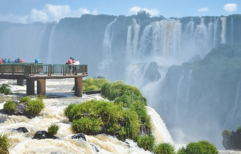 Iguazu falls national park on the border of Brazil and Argentina with tourists on wooden footbridges