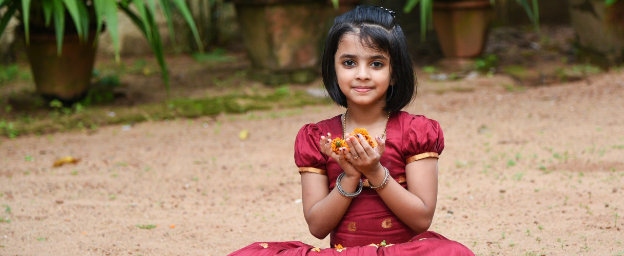 Girl holding flower in hand during Onam Festival Kerala Tour