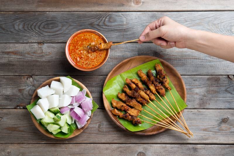 overhead-view-people-holding-chicken-satay