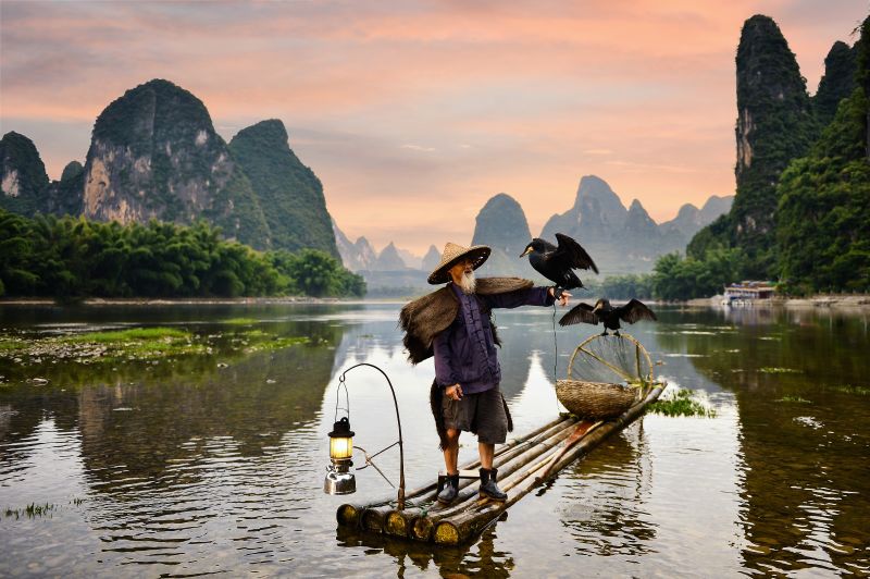 Fisherman of Guilin Li River and Karst mountains during the blue hour of dawn Guangxi China