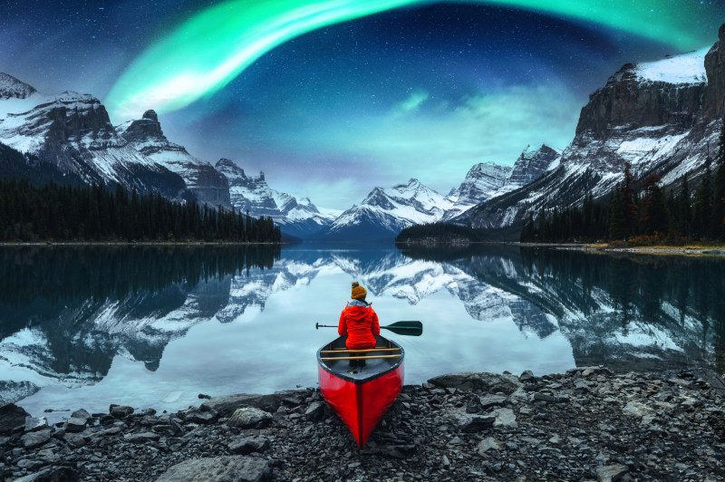 traveler-woman-sitting-on-canoe-aurora