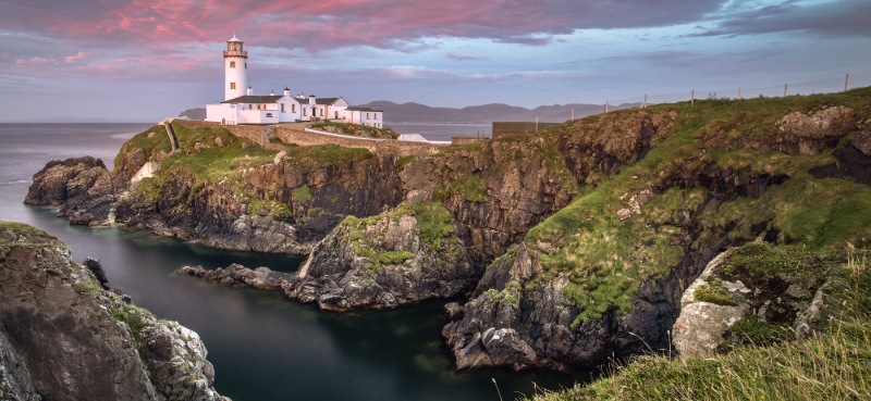 Enchanting Travels UK & Ireland Tours Donegal, Ireland. Fanad head at Donegal, Ireland with lighthouse at sunset. Colorful sky, mountains and sea