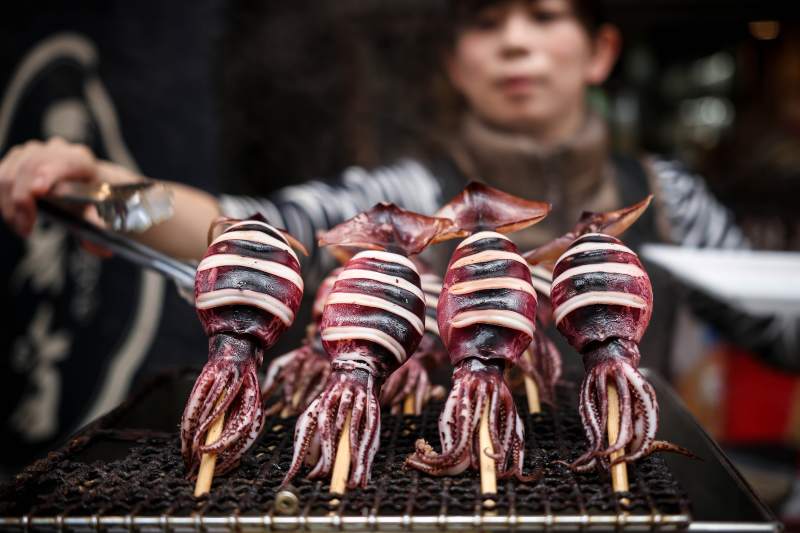 Nahaufnahme von Tintenfischspiessen auf einem Straßenmarkt in Osaka Japan