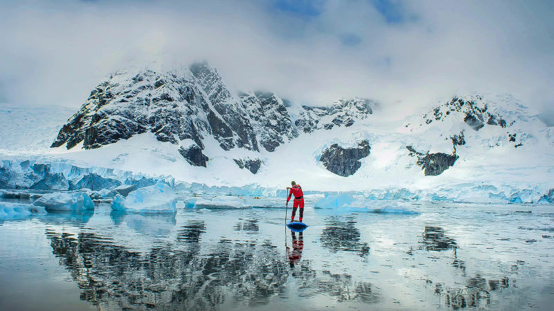 extreme adventure sport, Antarctica kayaking, paddling on kayak between antarctic icebergs, winter leisure outdoors activity