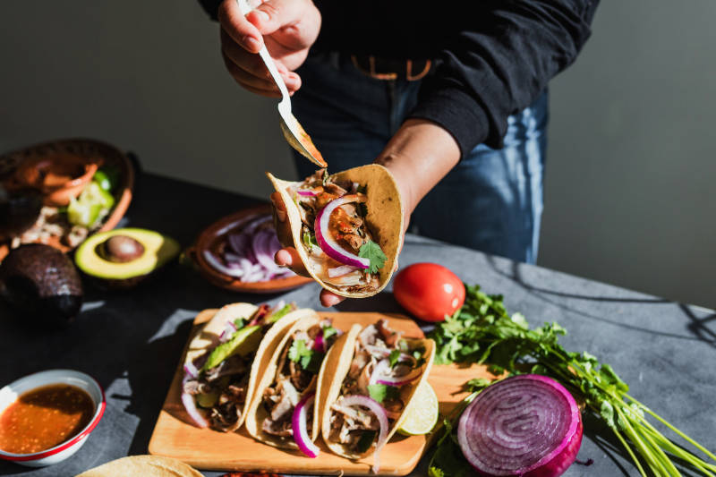 mexican woman hands preparing tacos carnitas