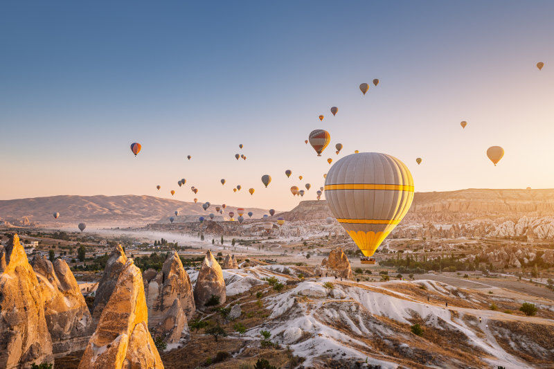 Beautiful panoramic view of the valley in Cappadocia with magical flying balloons and at sunset Turkey