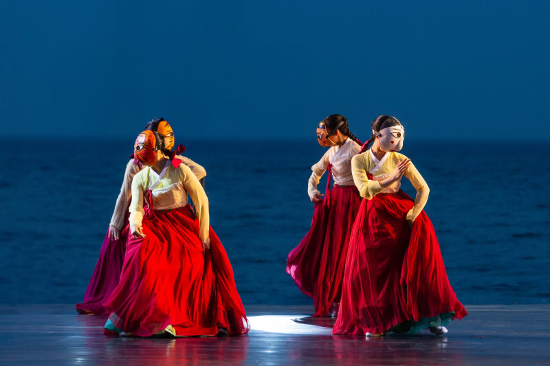 A Traditional Korean Dance Performance Wearing A Mask