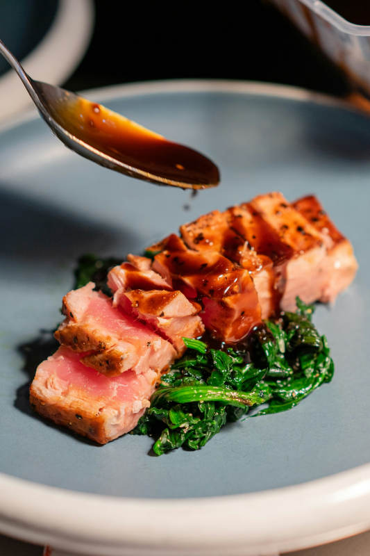raw meat with green vegetable on black plate hong kong