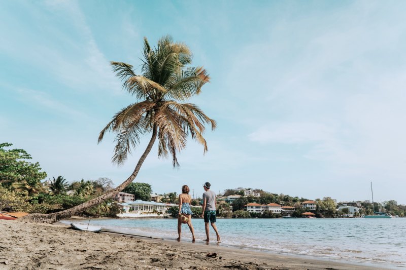 Reisendes Paar spaziert am Strand von Antigua, Grenada, Karibikinseln