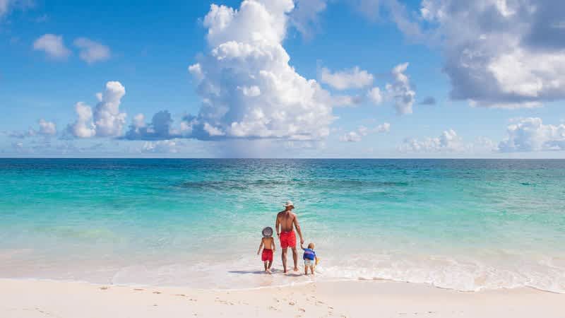 Father and sons walking on beach