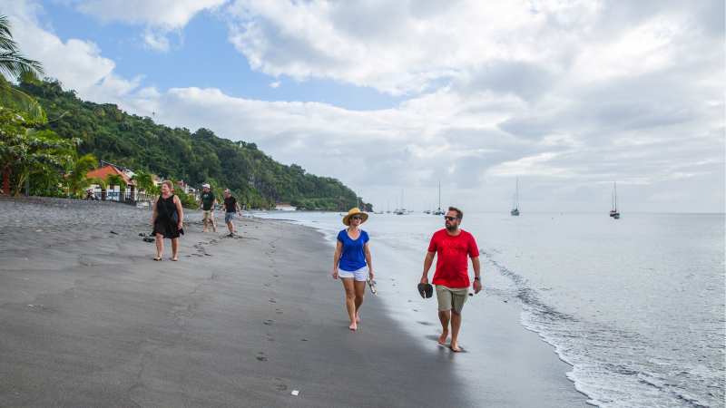 Couple walking on black sand beach
