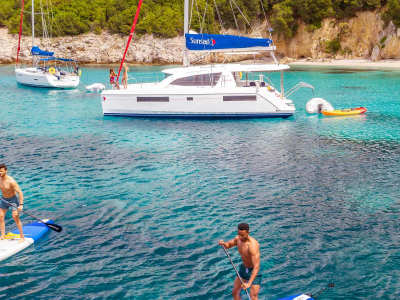 Catamaran Anchoring and People Stand Up Paddling Corfu Island