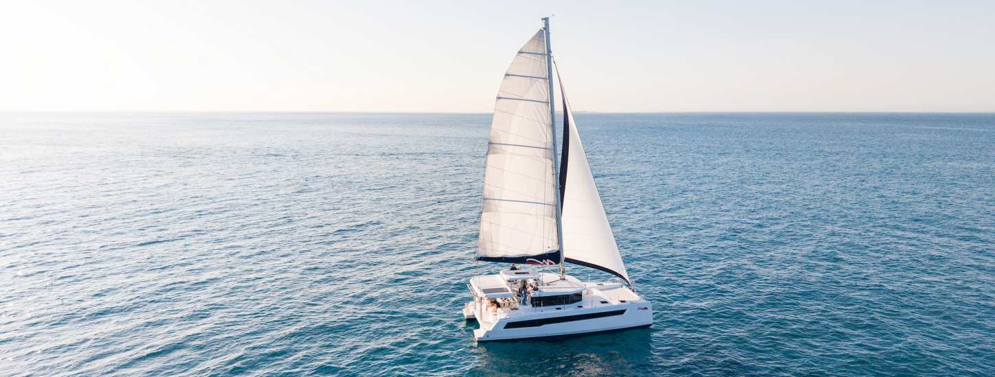 A sailing catamaran underway under full sail.