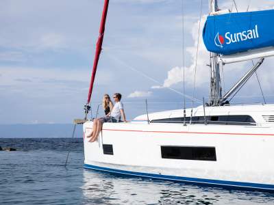 Couple sitting on monohull in Corfu Greece