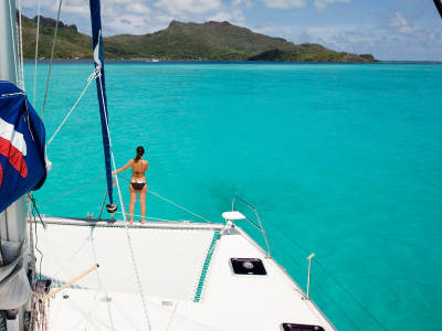 Woman on sailing catamaran trampoline